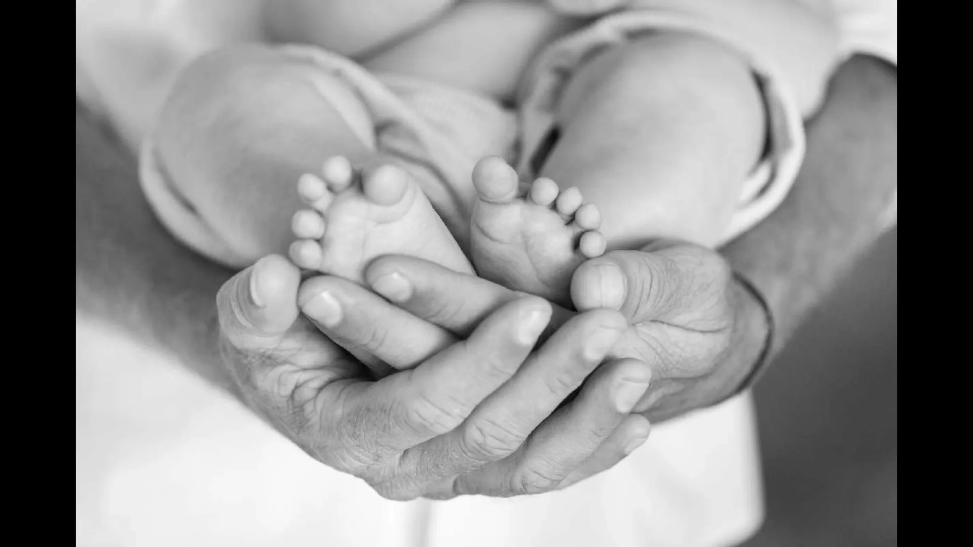 Eine &auml;ltere Hand h&auml;lt eine j&uuml;ngere Hand als Schutz